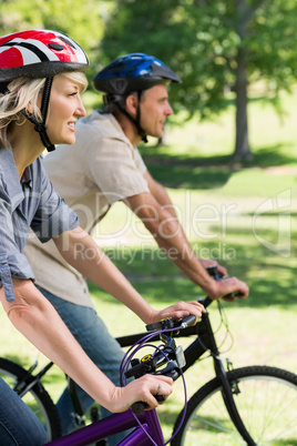 Couple riding bicycles in a park