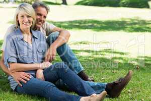 Happy couple sitting in park