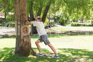 Man doing stretching exercise against tree