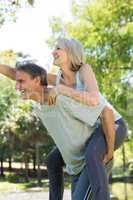 Couple enjoying piggyback ride in park