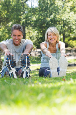 Happy couple stretching in park