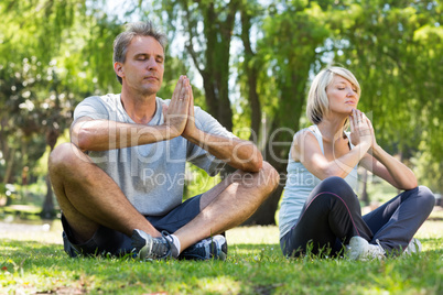 Couple meditating in park