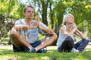 Couple meditating in park