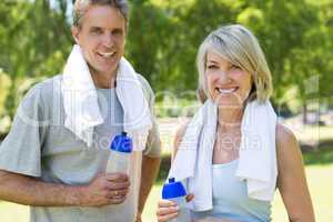 Couple holding water bottles in the park