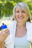 Woman holding water bottle in park