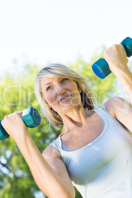 Woman lifting dumbbells in park