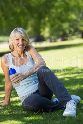 Sporty woman holding water bottle in park