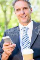 Businessman with mobile phone and disposable cup