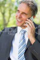 Happy businessman answering smartphone