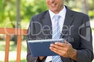 Midsection of businessman using digital tablet