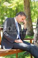 Sad businessman in park