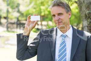 Confident businessman holding business card