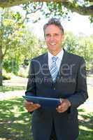 Happy businessman holding digital tablet