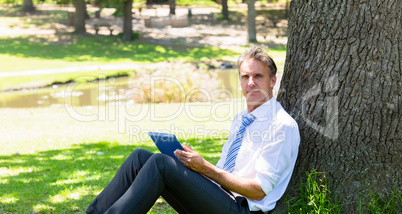 Businessman with tablet computer in park