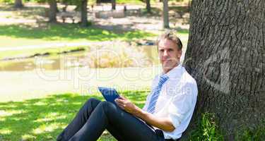 Businessman with tablet computer in park