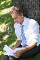 Businessman reviewing documents in park