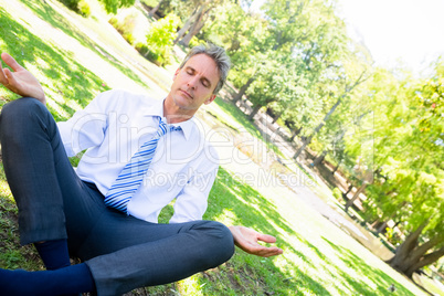 Businessman doing yoga in park