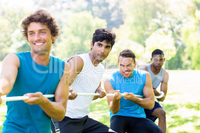 Friends playing tug of war in park