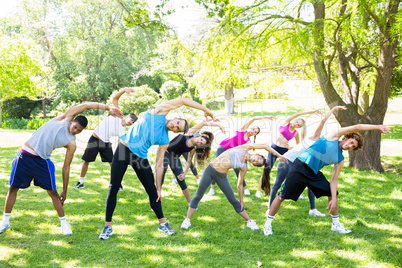 People doing stretching exercise in park