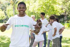 Volunteer pointing at tshirt in park