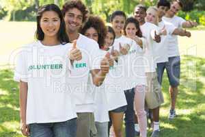 Volunteers gesturing thumbs up in park