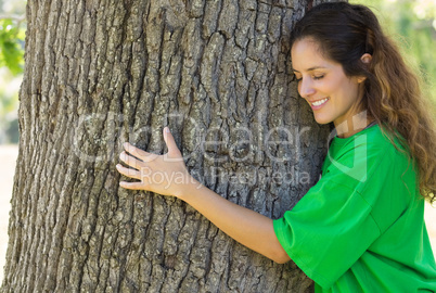 Environmentalist hugging tree trunk