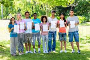Confident students holding blank papers