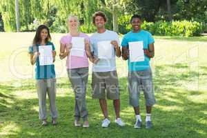 Friends holding blank papers on campus