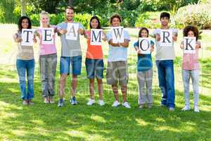 Friends holding placards reading teamwork