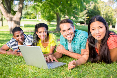 Smiling students with laptop on campus