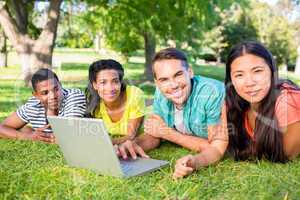 Smiling students with laptop on campus
