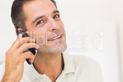 Closeup portrait of a smiling man using mobile phone