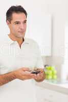 Smiling man text messaging at home