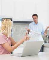 Couple with laptop and bill in the kitchen