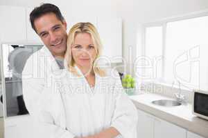 Man embracing woman from behind in kitchen