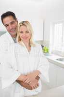 Man embracing woman from behind in kitchen