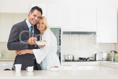 Woman embracing well dressed man in the kitchen