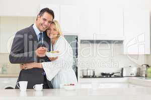 Woman embracing well dressed man in the kitchen