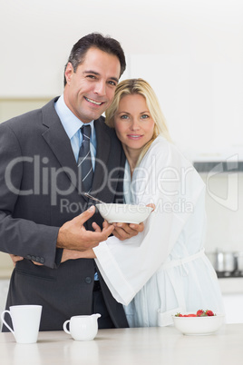 Portrait of a woman embracing well dressed man in kitchen