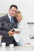Portrait of a woman embracing well dressed man in kitchen