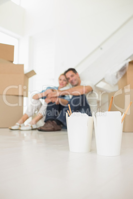 Takeaway food with blurred couple and boxes at new house
