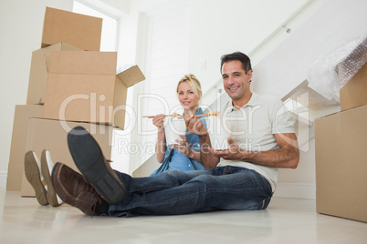 Couple with takeaway food and boxes in a new house