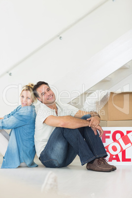 Smiling couple with boxes in a new house