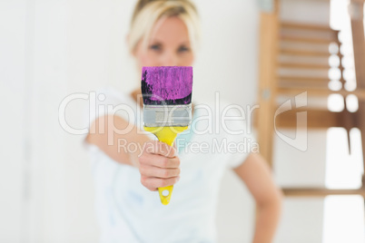 Blurred woman holding paint brush at new house