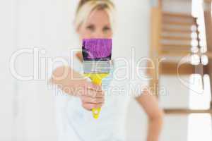 Blurred woman holding paint brush at new house