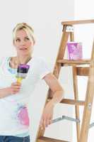 Beautiful woman with paint brush looking away in new house