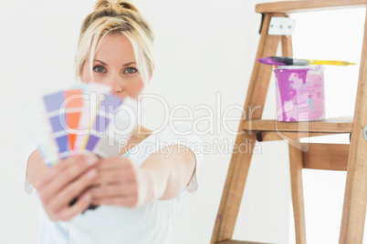 Woman holding blurred color swatches in new house