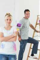 Couple with paint brush and ladder in a new house