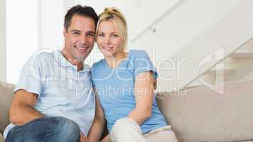 Portrait of a loving couple sitting on sofa in living room