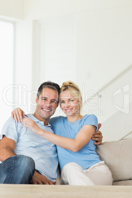 Portrait of a loving couple sitting on sofa in living room
